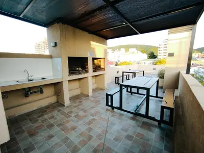 a patio with a table and a fireplace on a building at Departamento MIRALEJOS 14 in Villa Carlos Paz