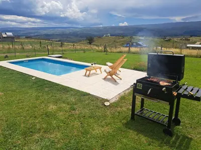 a grill and a smoker next to a swimming pool at Ullasa - Casa de Montaña in Villa Yacanto