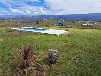 a swimming pool in the middle of a grass field at Ullasa - Casa de Montaña in Villa Yacanto