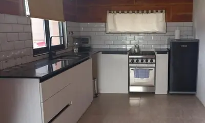 a kitchen with a stove and a refrigerator at Ullasa - Casa de Montaña in Villa Yacanto