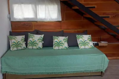 a green bed with pillows on top of it at Ullasa - Casa de Montaña in Villa Yacanto