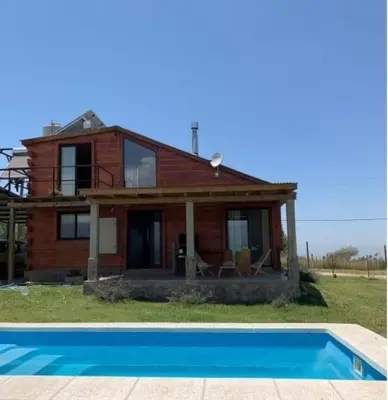 a house with a swimming pool in front of it at Ullasa - Casa de Montaña in Villa Yacanto