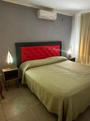 a bedroom with a large bed with a red headboard at Ayres de las Sierras Villa Carlos Paz in Villa Carlos Paz