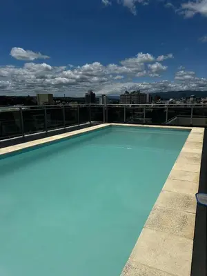 a blue swimming pool on the roof of a building at Ayres de las Sierras Villa Carlos Paz in Villa Carlos Paz