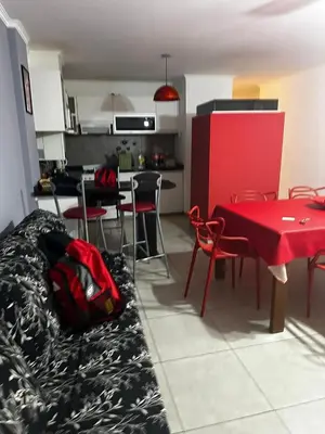 a living room with a red table and chairs at Ayres de las Sierras Villa Carlos Paz in Villa Carlos Paz