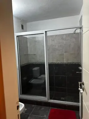 a bathroom with a glass shower with a toilet at Ayres de las Sierras Villa Carlos Paz in Villa Carlos Paz