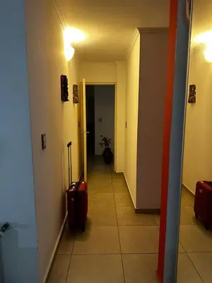 a hallway with a room with a door and a suitcase at Ayres de las Sierras Villa Carlos Paz in Villa Carlos Paz