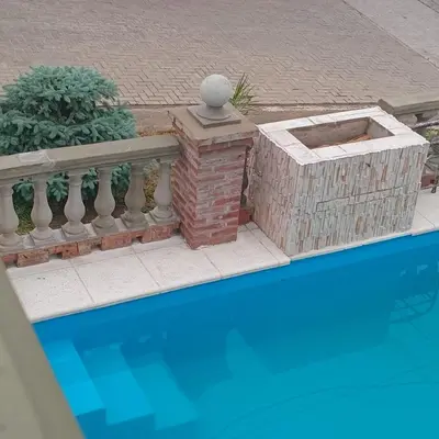 a swimming pool with a stone fence and a brick wall at Mis 4 Soles in Santa María