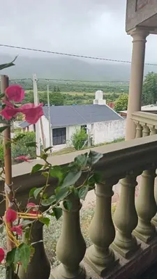 a flower in a vase sitting on a porch at Mis 4 Soles in Santa María