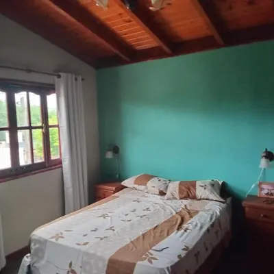 a bed in a room with a green wall at Mis 4 Soles in Santa María