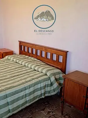 a bed in a room with a sign on the wall at El descanso casita en alquiler in Taninga
