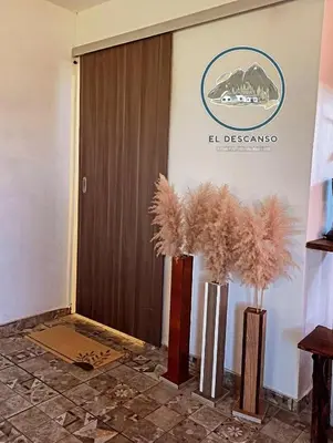 a lobby with two vases with trees in front of a door at El descanso casita en alquiler in Taninga