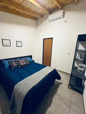 a bedroom with a blue bed and a shelf at Los colibríes in Tanti