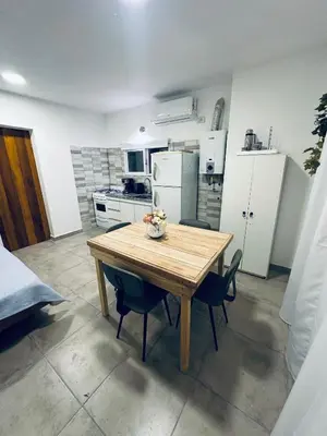 a kitchen with a wooden table and some chairs at Los colibríes in Tanti