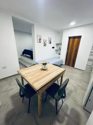 a wooden table and chairs in a room at Los colibríes in Tanti