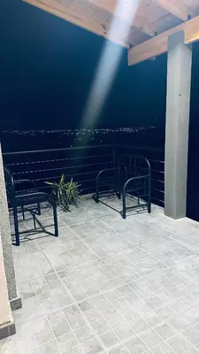 two benches sitting on a patio looking at the water at Los colibríes in Tanti