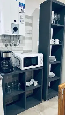 a microwave sitting on a shelf in a kitchen at Los colibríes in Tanti