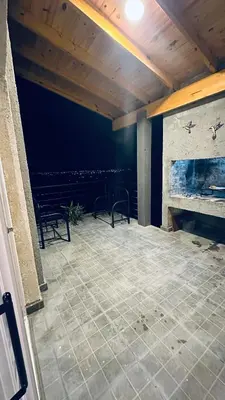 a patio with two chairs and a fireplace at Los colibríes in Tanti