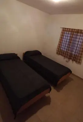 two beds in a room with a window at La casa de Los Abuelos in La Bolsa