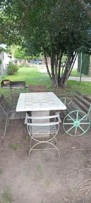 a picnic table and two benches in a park at La casa de Los Abuelos in La Bolsa