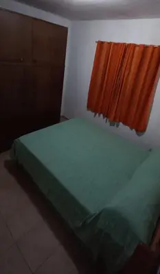 a bedroom with a green bed with an orange window at La casa de Los Abuelos in La Bolsa