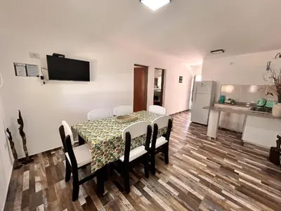 a dining room with a table and chairs and a kitchen at Carpe Diem Cabañas en Panaholma in Panaholma