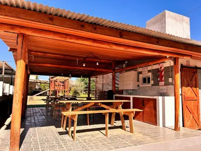 a wooden pavilion with a table and a kitchen at Carpe Diem Cabañas en Panaholma in Panaholma