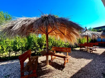 a table and benches under a straw umbrella at Carpe Diem Cabañas en Panaholma in Panaholma