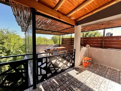 an outdoor deck with a wooden roof and a table at Carpe Diem Cabañas en Panaholma in Panaholma