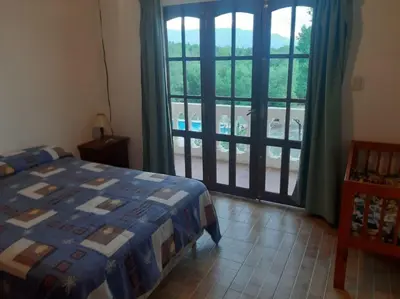 a bedroom with a bed and a sliding glass door at El Cabañal in Mina Clavero