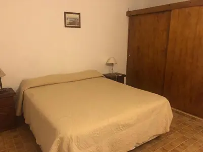 a bedroom with a bed and a wooden door at El Cabañal in Mina Clavero