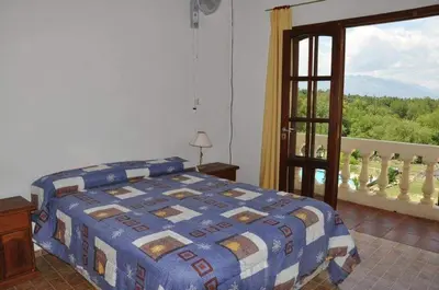 a bedroom with a bed and a large window at El Cabañal in Mina Clavero