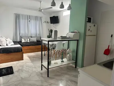 a kitchen and living room with a table and a refrigerator at Cabañas Vicentico in Mina Clavero