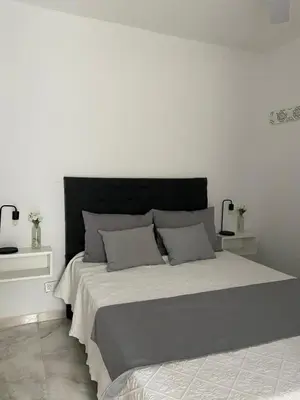 a bedroom with a large bed with a black headboard at Cabañas Vicentico in Mina Clavero