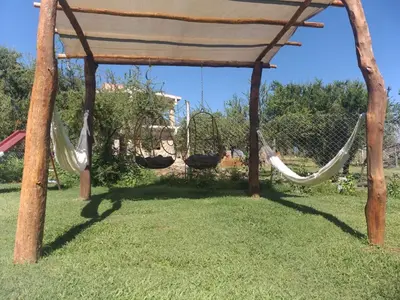 a swing set with hammocks in a yard at Cabañas Vicentico in Mina Clavero