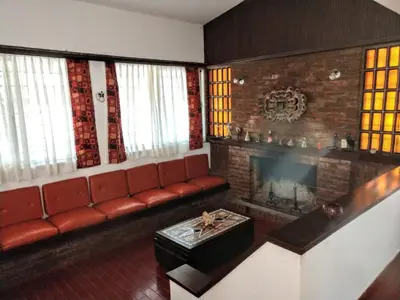 a living room with a couch and a fireplace at Casa frente al rio San Antonio Playas de Oro Villa Carlos Paz in Villa Carlos Paz