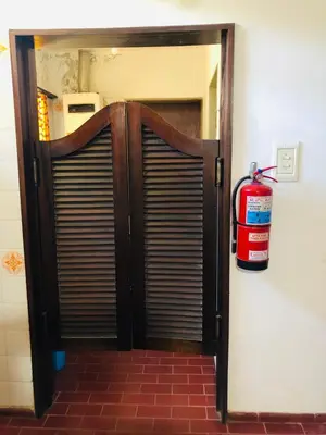 a fire extinguisher is sitting next to a door at Casa frente al rio San Antonio Playas de Oro Villa Carlos Paz in Villa Carlos Paz