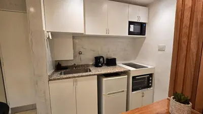 a small kitchen with white cabinets and a sink at Terrazas de San Juan in Cordoba