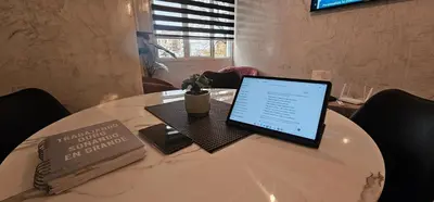 a laptop computer sitting on a table with a book at Terrazas de San Juan in Cordoba