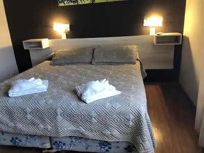 a bedroom with a bed with two towels on it at Costanera Hotel in Villa Carlos Paz