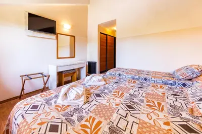 a bedroom with a bed with a colorful comforter at Costanera Hotel in Villa Carlos Paz