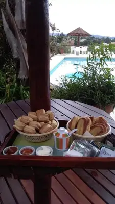a tray of bread and pastries on a table next to a pool at Soles del lago in Villa Carlos Paz