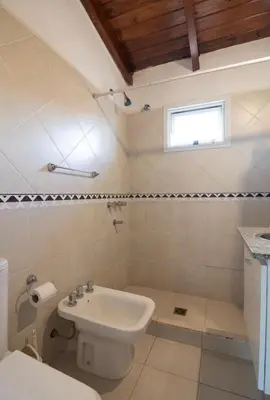 a bathroom with a sink and a toilet and a window at Soles del lago in Villa Carlos Paz