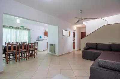 a living room with a couch and a dining room at Soles del lago in Villa Carlos Paz