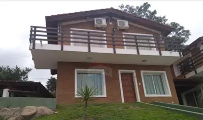 a house with a balcony on top of it at Soles del lago in Villa Carlos Paz