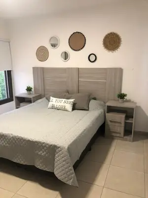 a bedroom with a bed and two mirrors on the wall at Terra Bella PA in Villa Carlos Paz