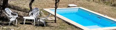 three chairs and a swimming pool in a yard at Terra Bella PA in Villa Carlos Paz