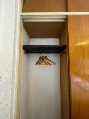 a closet with a wooden hanger in a room at Departamento en Nueva Córdoba in Cordoba