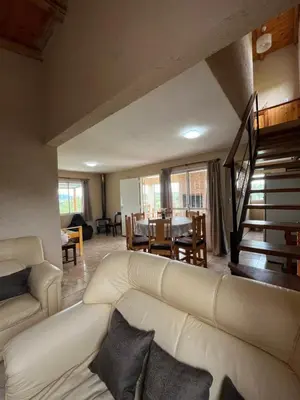 a living room with a white couch and a table at Cabañas aires de montaña in Villa Parque Siquiman
