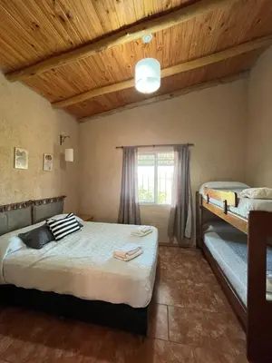 a bedroom with two beds and a wooden ceiling at Cabañas aires de montaña in Villa Parque Siquiman